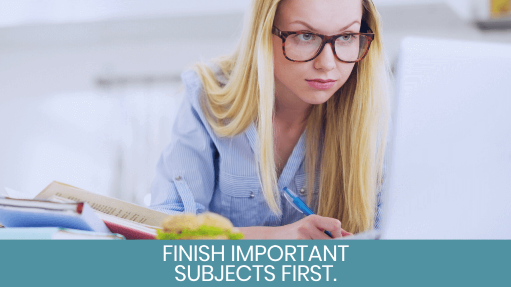 Woman looking at laptop and writing on notebook