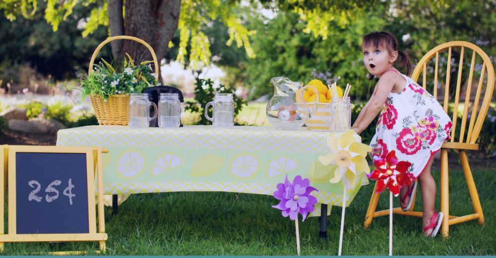 Little girl selling lemonades, looking surprised