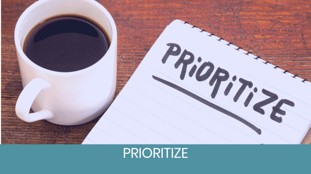 Prioritize note with a coffee mug next to it