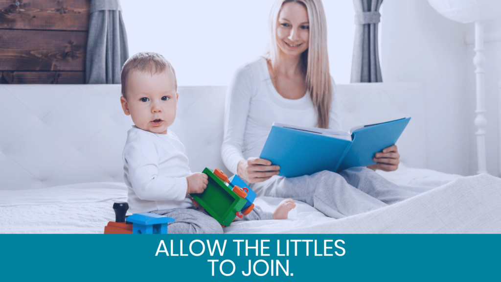 Woman smiling at camera with a book and baby next to her