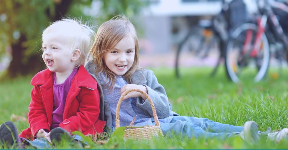 Two small girls at a park smiling