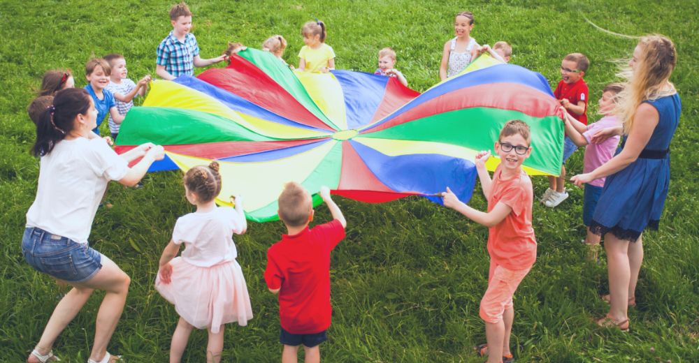 Kids playing with colorful blanket outside